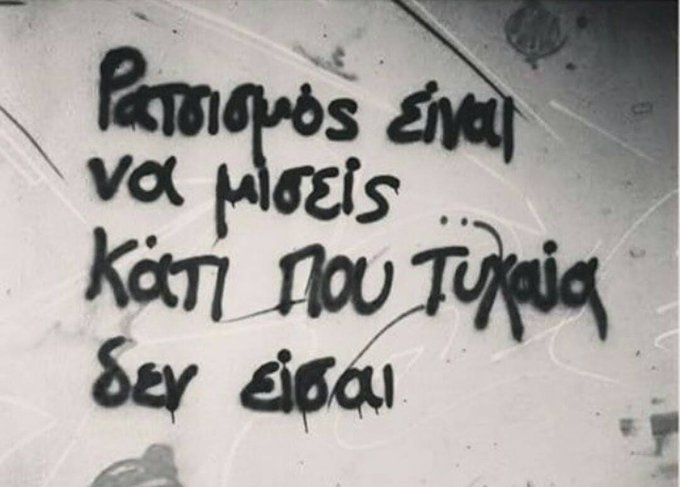 Η εικόνα παρουσιάζει graffiti στο τοίχο με το εξής μήνυμα: «Ρατσισμός είναι να μισείς κάτι που τυχαία δεν είσαι».